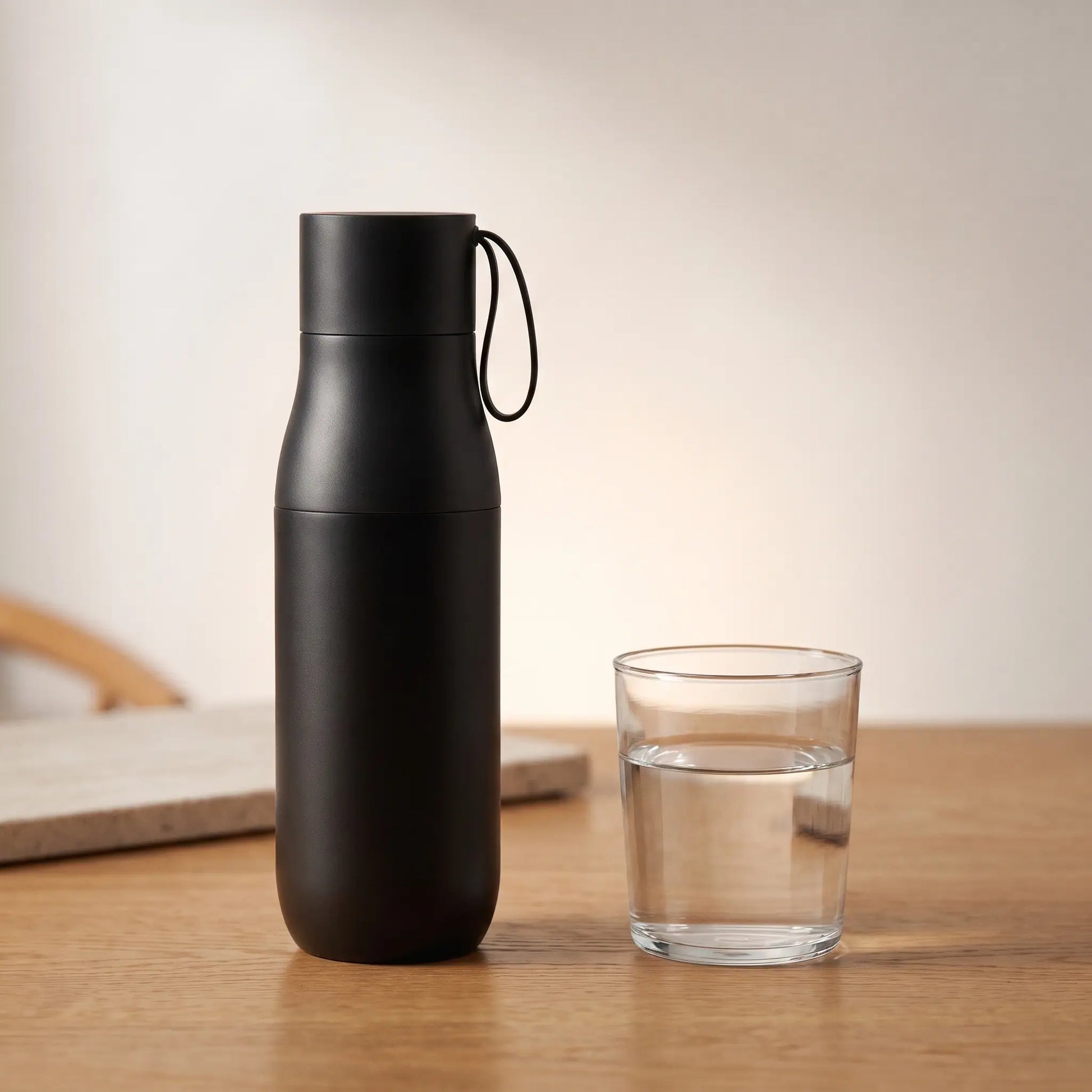 The Ritual Bottle beside a glass of water