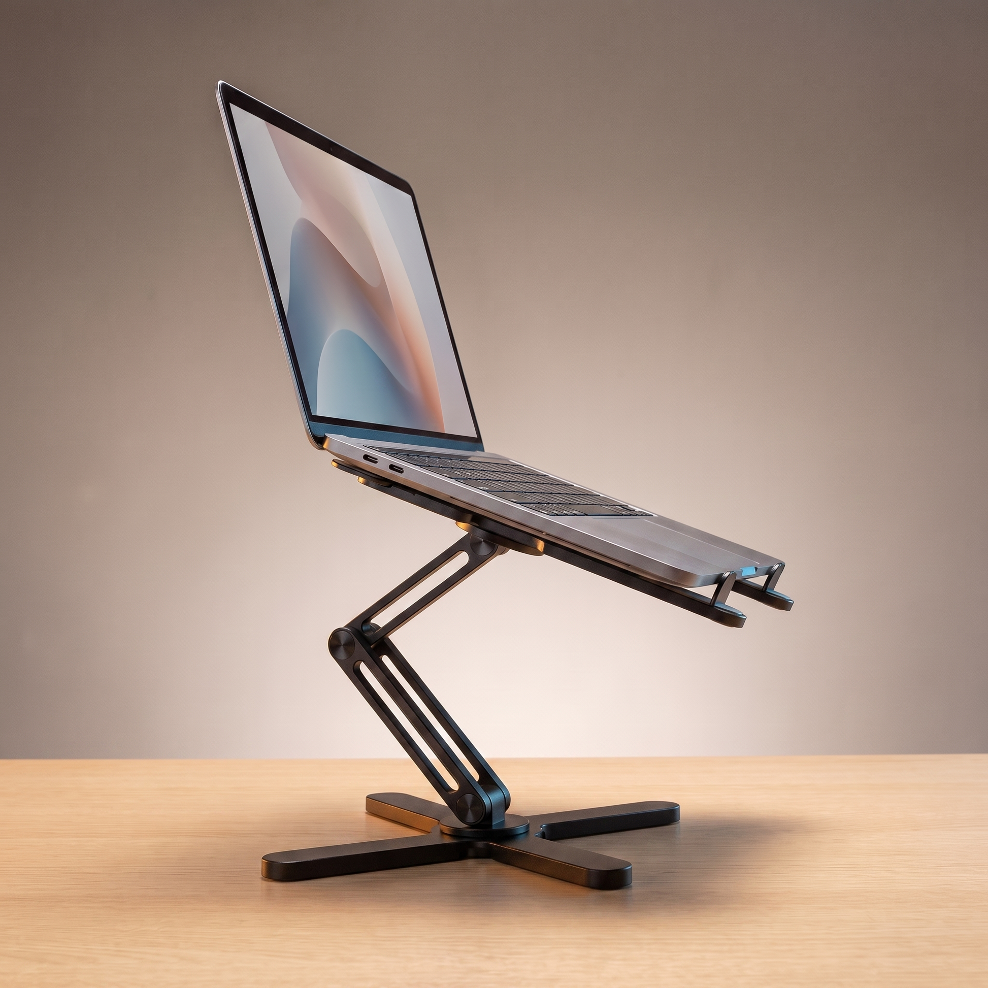 The Pivot laptop riser in Matte Black, holding a laptop at eye level